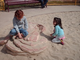 two children playing in the sandbox at park day